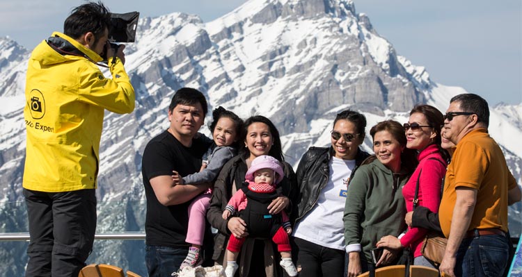 A family poses for a photo taken by a professional Banff Gondola photographer