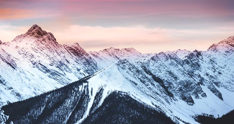 A mountain range glowing with pink and purple hues along the peaks.