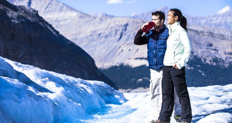 Two people stand on the Columbia Icefield.