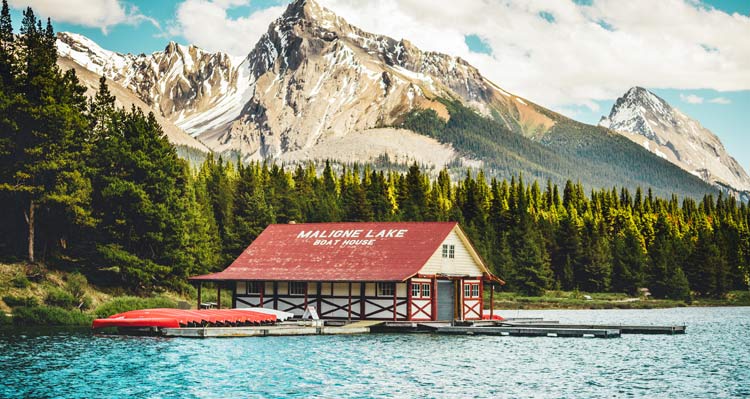 The Maligne Lake Boat House below forested mountain sides.