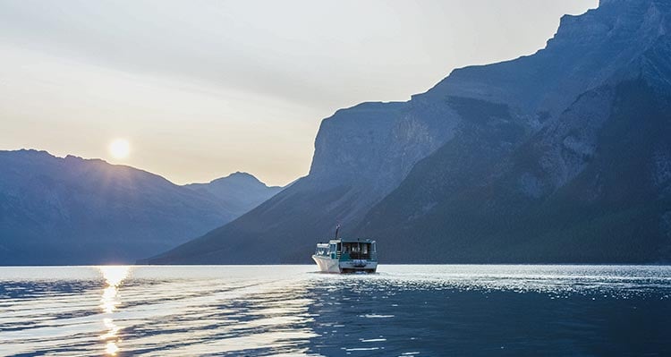 A boat cruises on a mountain-sided lake