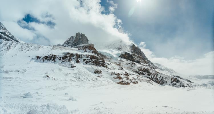 A glacier high above and between two mountain peaks.