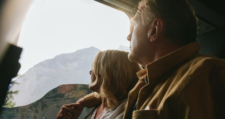 Two people look out the window on a bus.