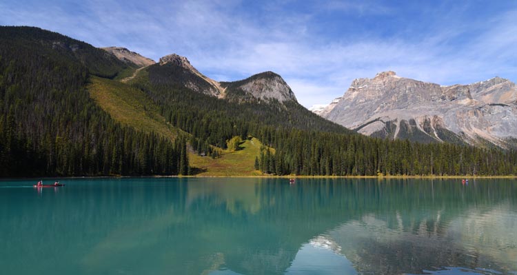 A blue lake below forested mountains.