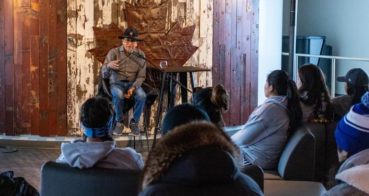 Roland Rollinmud speaks to a group of students