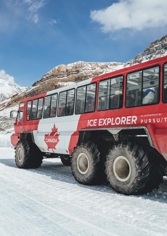 An Ice Explorer vehicle drives along an ice road on the Athabasca Glacier