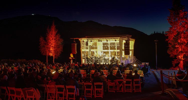 A concert stage at night time under a dark sky.