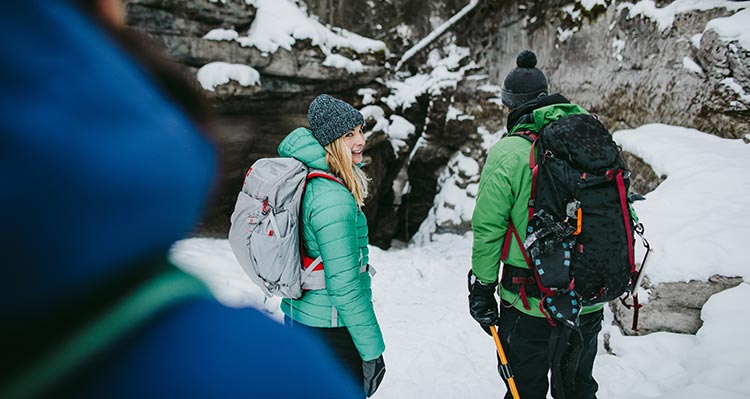 A group of people walk through an icy canyon.