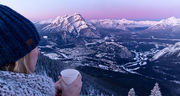 A person overlooks a valley with a small town.