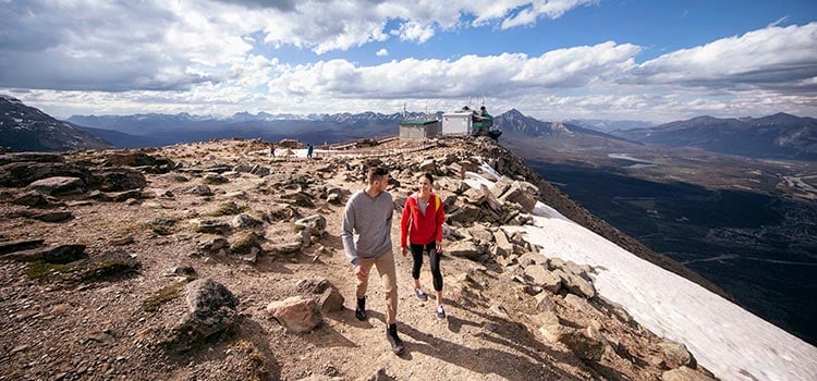 Two hikers at the top of a rocky mountain peak