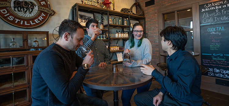 a group of people sample liquor in a tasting room