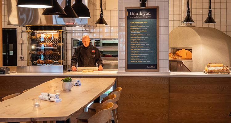 A chef prepares food in an open view kitchen.