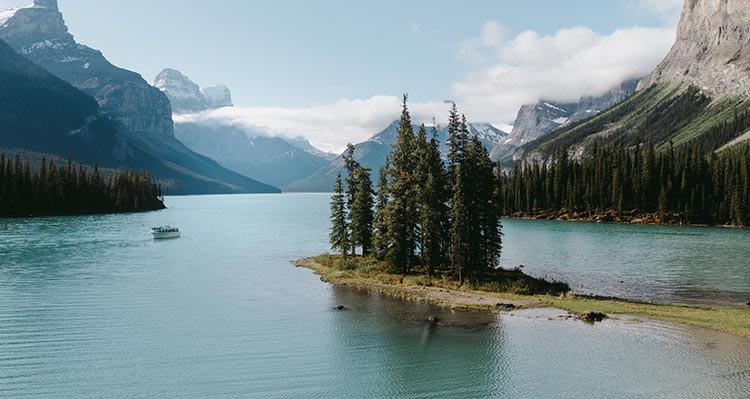 A tree-covered peninsula on a blue lake.