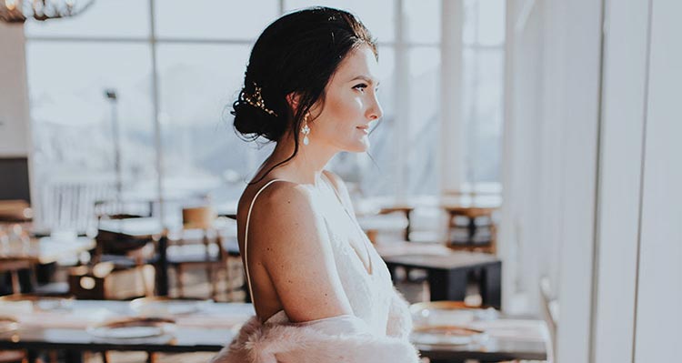 A bride looks out a window from a restaurant.