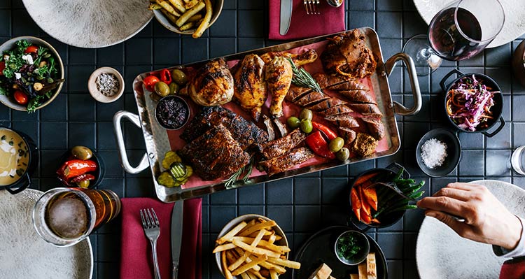 A platter of smoked meats and side dishes.