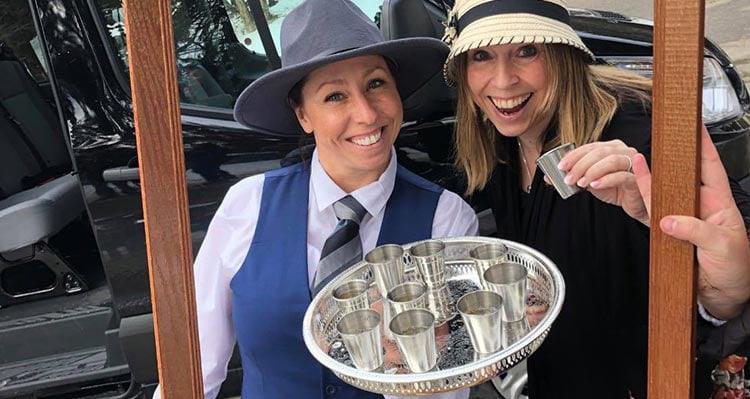 A tour guide holds a tray of drinks