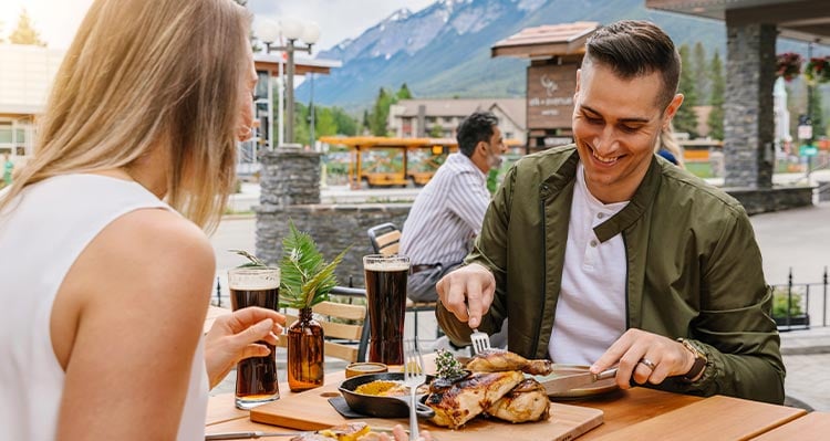 Two people eat at a restaurant patio.