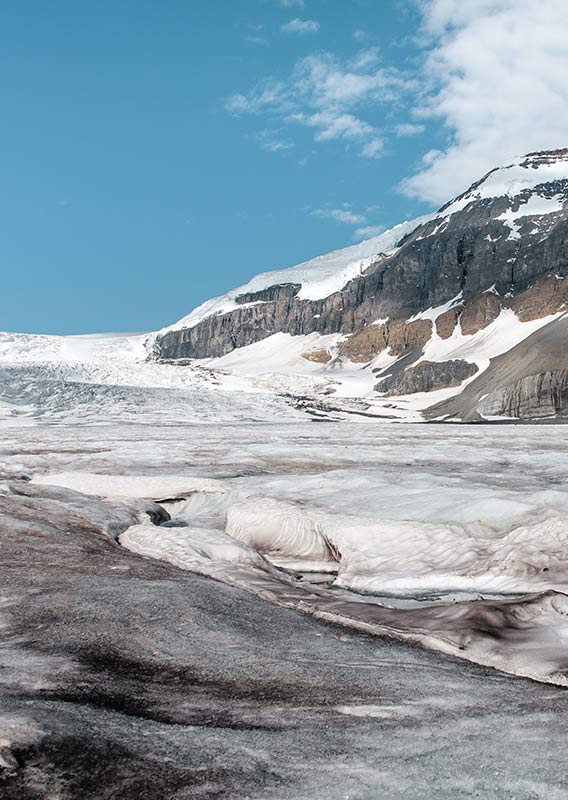 A view of a glacier below tall cliffsides.