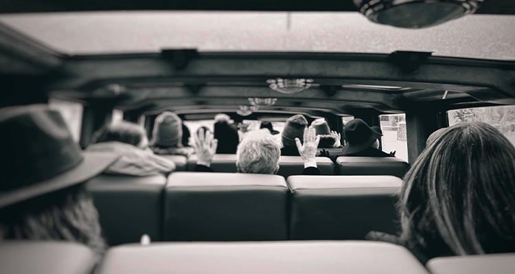 A view from behind a group of people on a tour bus.