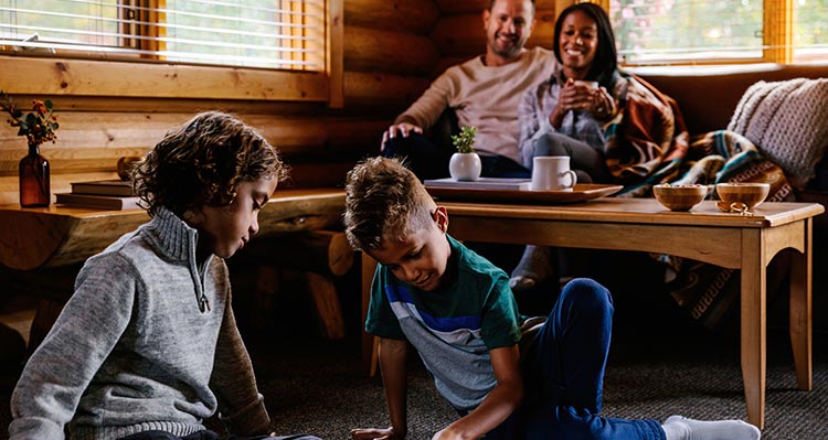 A family sits in a cabin living area.