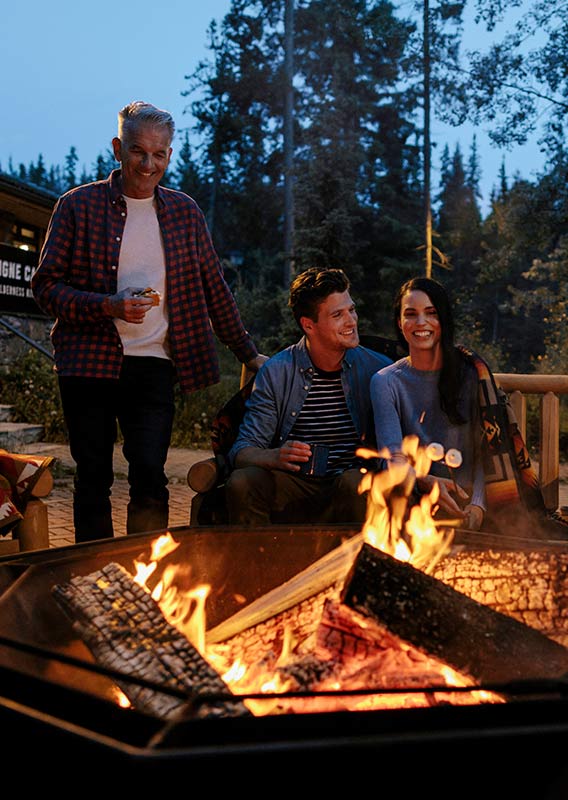 A group of people sit around a campfire.