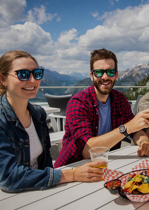 Friends sit together on rooftop patio in mountains