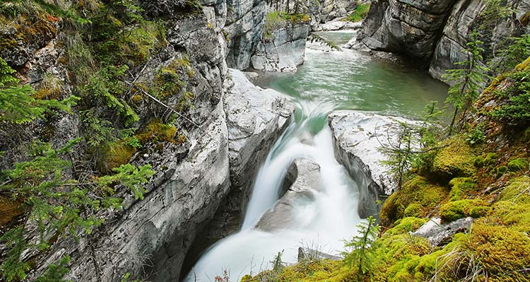 A waterfall rushing through a rocky canyon.