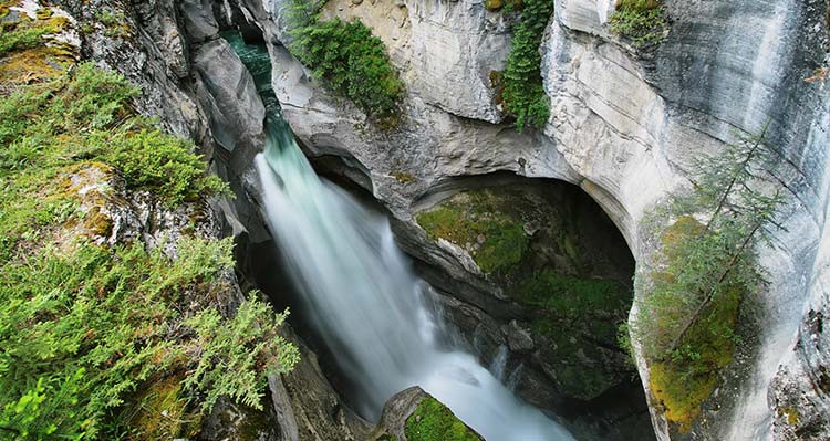 A waterfall rushed through a rocky canyon.