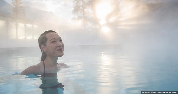 A woman relaxes in steaming water.