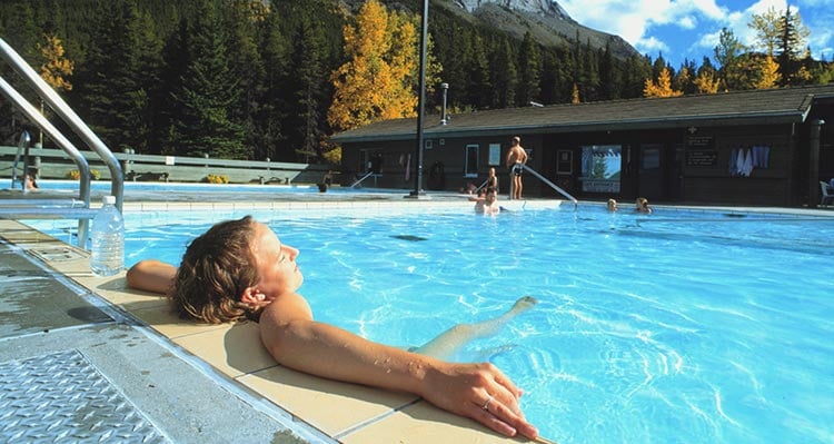 A person relaxes in a hot springs pool.