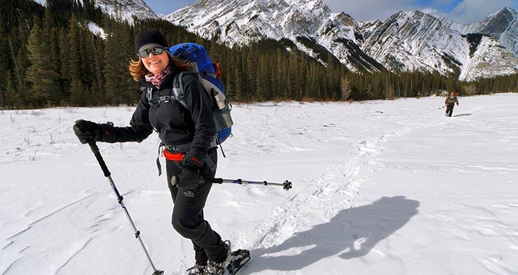 A person snowshoes along a frozen field.