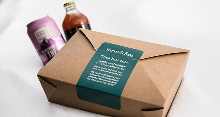 A takeout container from a restaurant with some drinks.