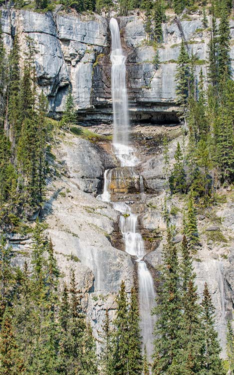 A tall waterfall crashes across cliffs.