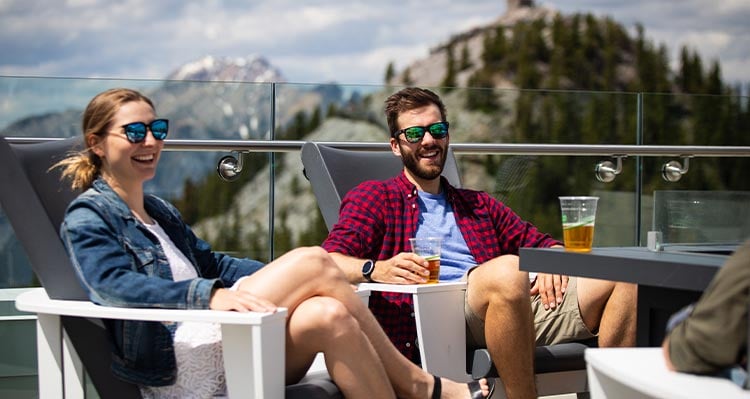 A couple laughs on the patio while having a beverage