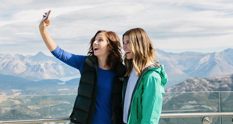 Two ladies take a selfie at the top of the mountain