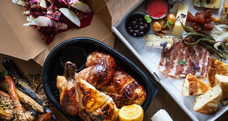 A spread of delicious food sitting in take out boxes