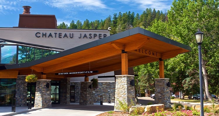 Hotel exterior image of Chateau Jasper with a large awning fixture covering the entrance in the summer season.