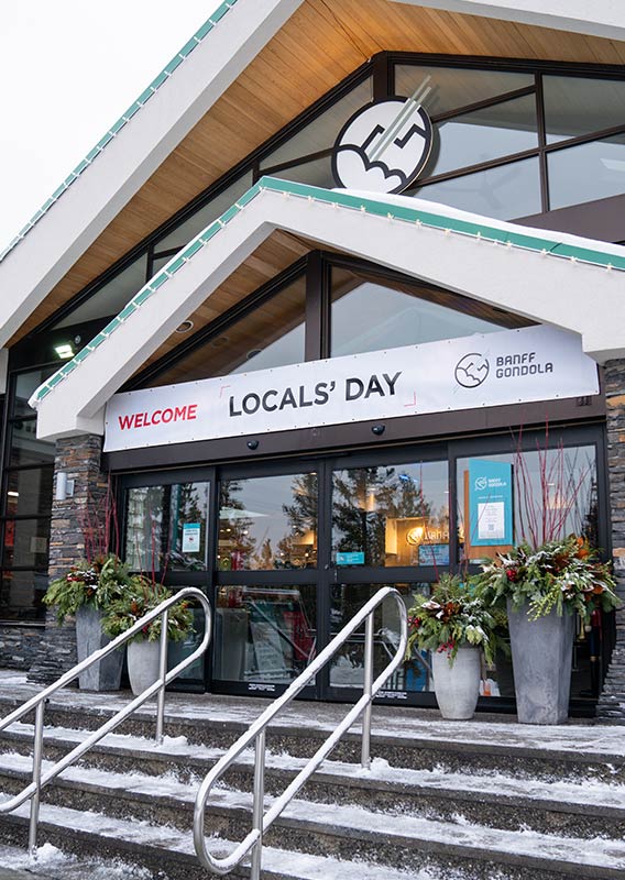 Exterior of a Banff Gondola building with a sign above the door that says "Locals' Day"