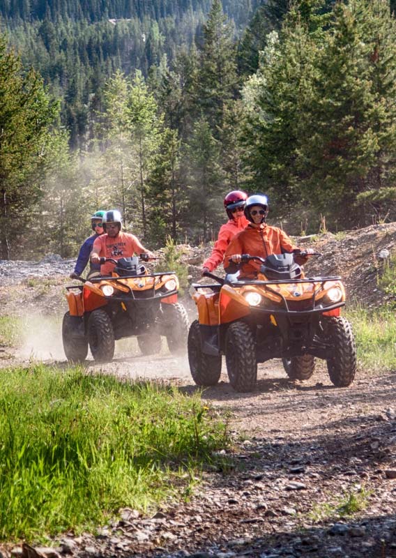 Two all-terrain vehicles drive along a rocky path