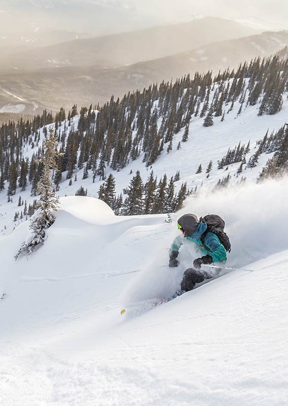 A skier makes a big turn on a snowy mountainside