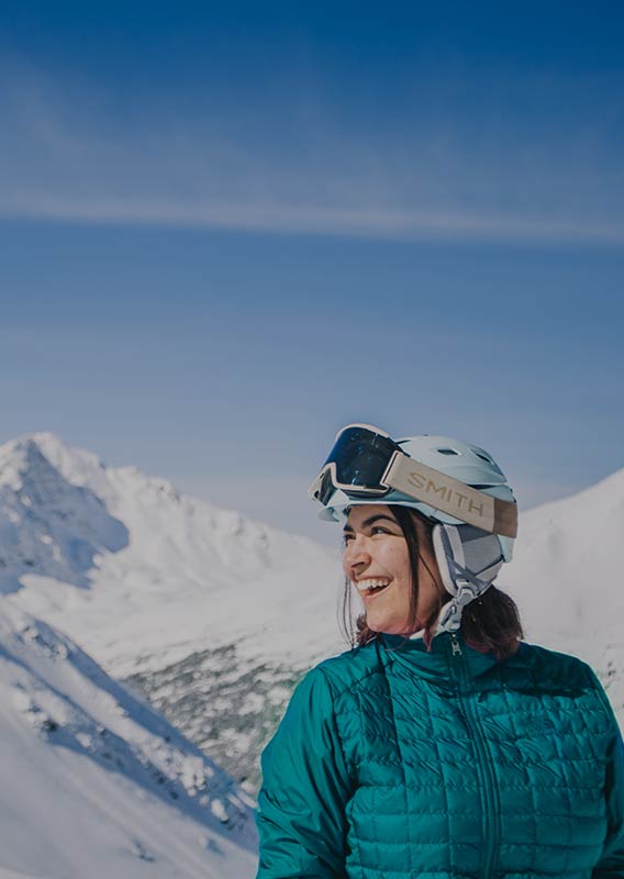 A woman in a ski helmet on a snowy mountain