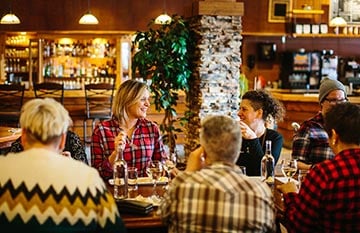 A group of people sit at a restaurant dining table.