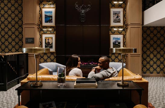 Two people sit in a leather sofa in a luxury hotel lobby