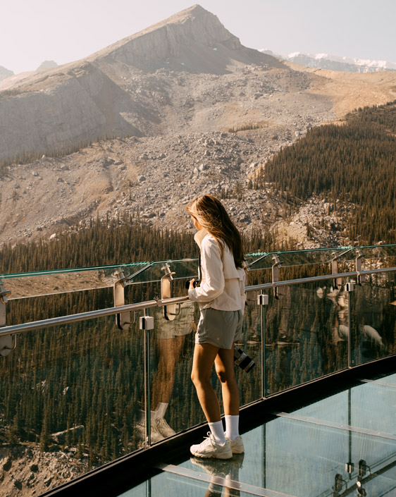 A person standing at the banister of the Columbia Icefield Skywalk, looking at the view.