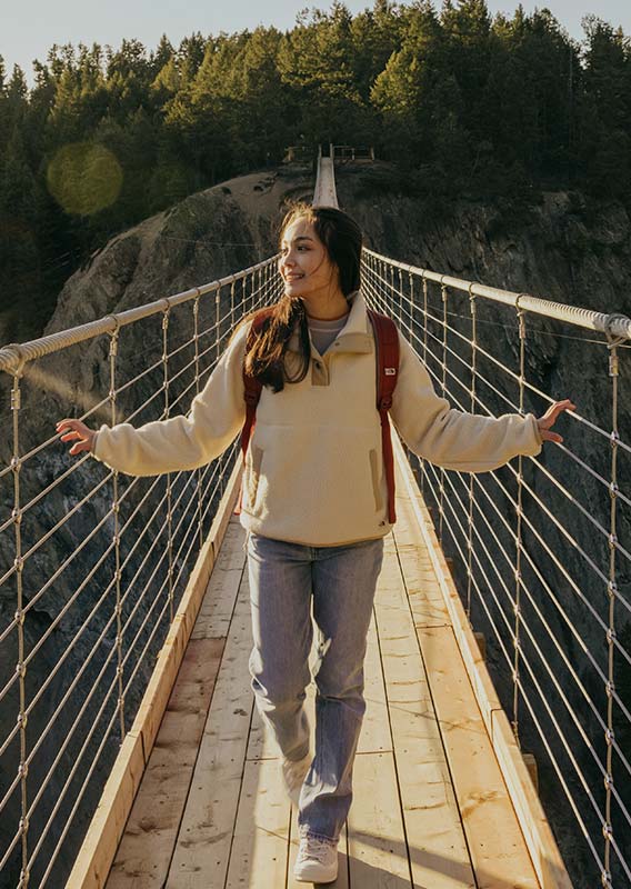 A person walking across the Golden Skybridge, looking at the view