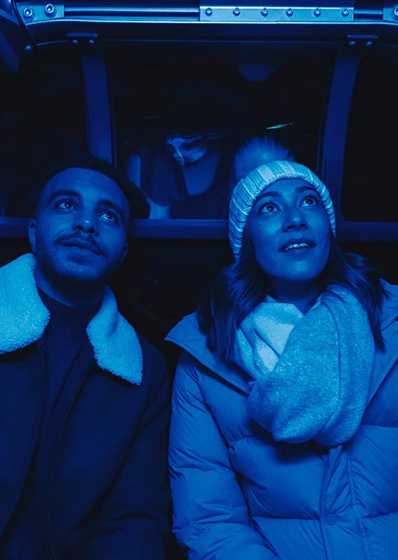 A couple in a Banff Gondola carriage while in blue light.
