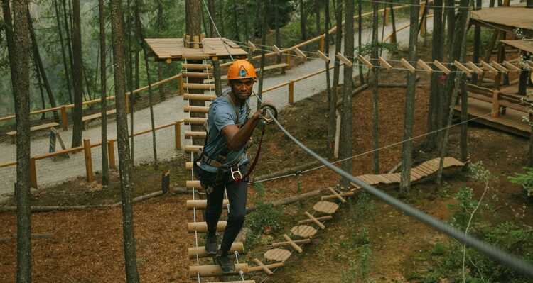 A person walking through the treetop course at Golden Skybridge