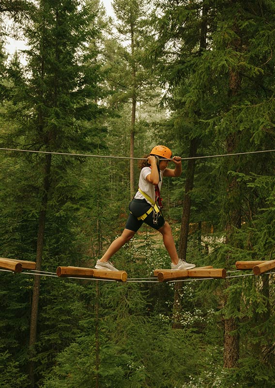 A child walks across the Canyon Edge Challenge course.