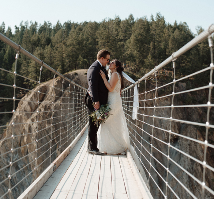 A married couple standing standing facing each other on Golden Skybridge