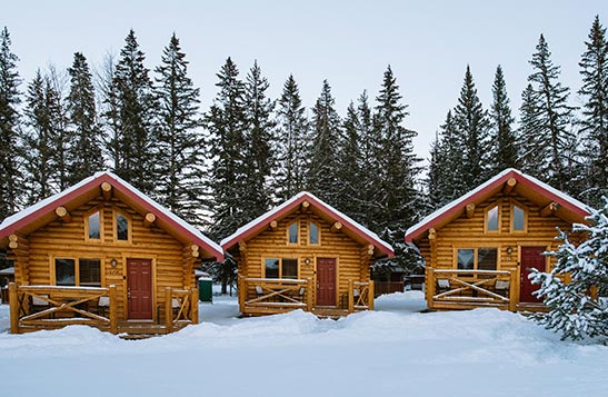A hotel room with large bed with balcony doors.